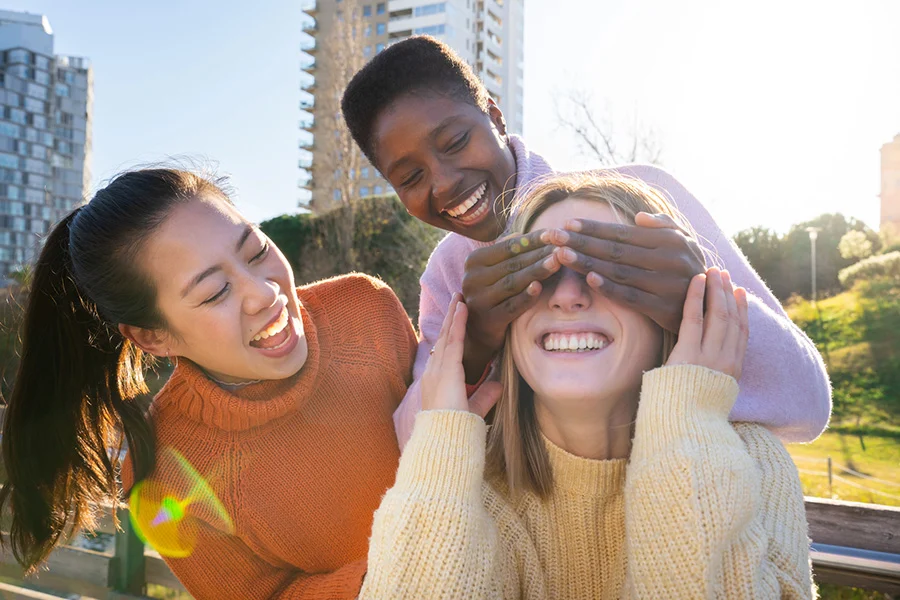 three diverse friends laughing playfully, showing positive social support for those dealing with bulimia nervosa