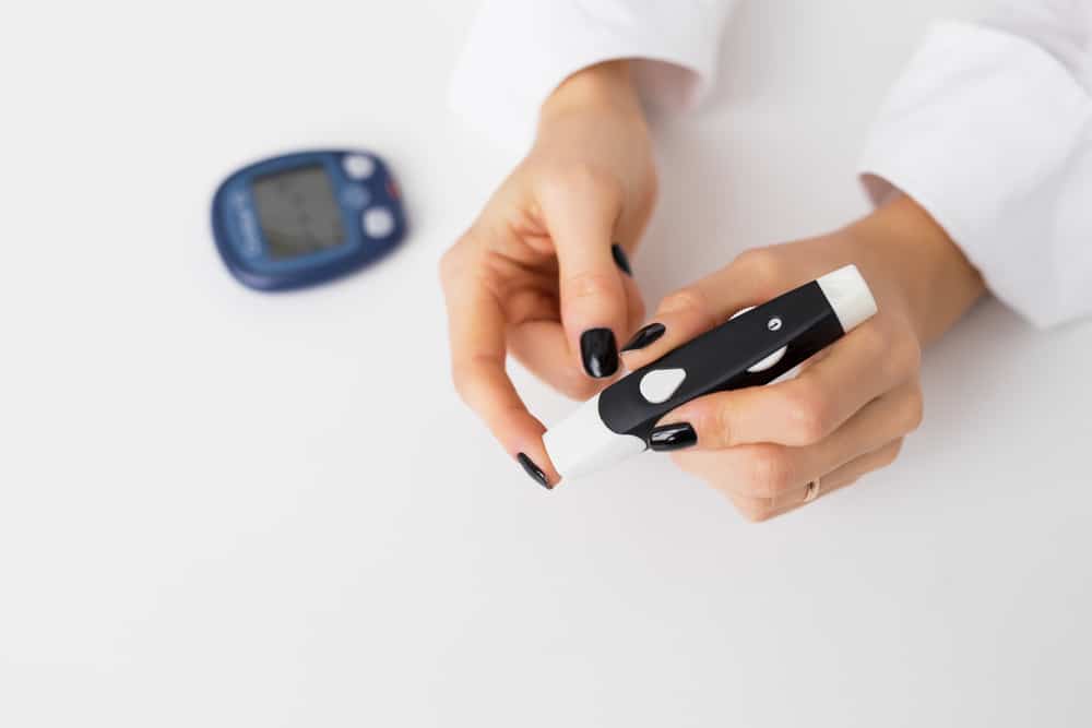 a woman using a diabetes kit